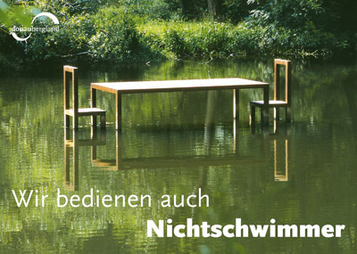 Postkartenmotiv von Donaubergland, Großer Tisch mit Stühlen im Wasser. 